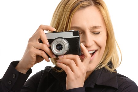 young attractive woman taking a shot with retro photo camera, isolated over whiteの写真素材