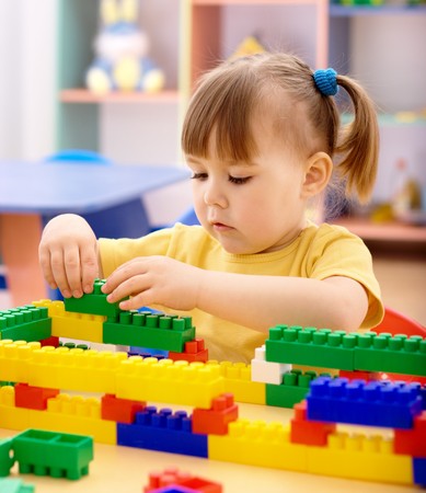 Cute little girl play with building bricks in preschoolの写真素材