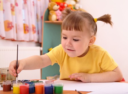 Cute cheerful child play with paints in preschoolの写真素材