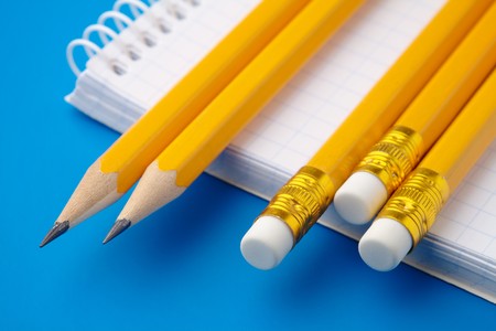 Notepad and few pencils on blue background, shallow depth of fieldの写真素材