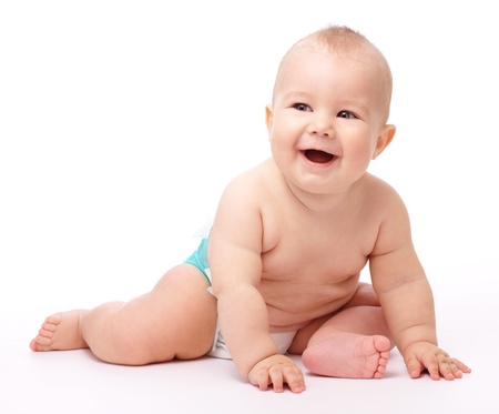 Happy child is sitting on floor, isolated over whiteの写真素材