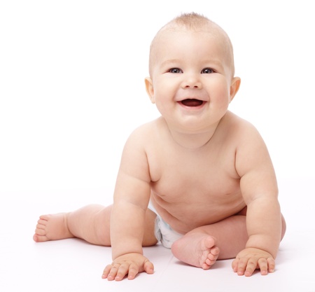 Happy child is sitting on floor, isolated over whiteの写真素材