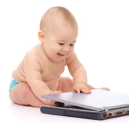 Little baby boy is sitting on floor with his laptop, isolated over whiteの写真素材