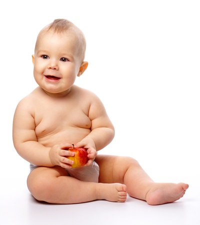 Portrait of a cute little child with red apple, isolated over whiteの写真素材