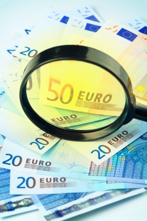 Small heap of Euro currency under a magnifying glass,の写真素材