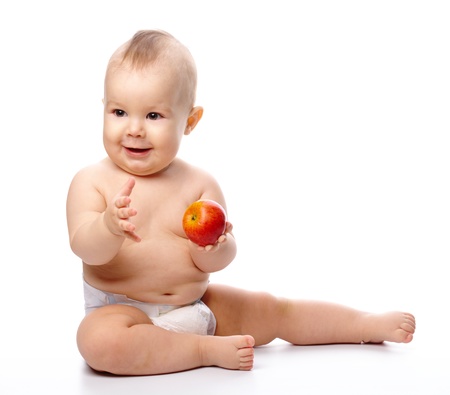 Portrait of a cute little child with red apple, isolated over whiteの写真素材