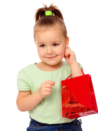 Cute little girl with red shopping bag, isolated over whiteの写真素材