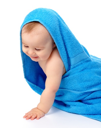 Happy little child wrapped in blue towel, isolated over whiteの写真素材