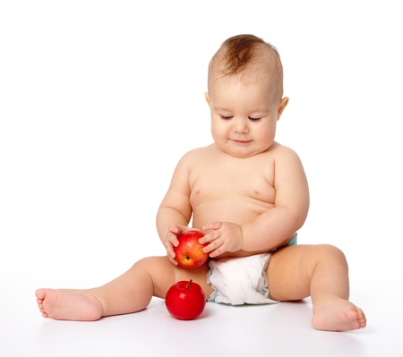 Portrait of a cute little child with two red apples, isolated over whiteの写真素材