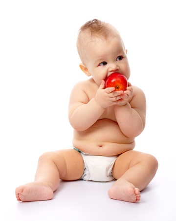 Cute little child is going to bite red apple, isolated over whiteの写真素材