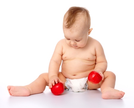Portrait of a cute little child with two red apples, isolated over whiteの写真素材