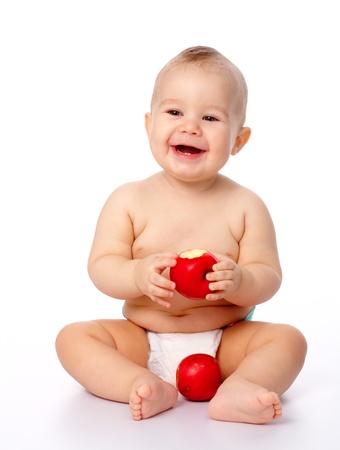 Portrait of a cute little child with two red apples, isolated over whiteの写真素材