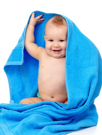 Happy little child wrapped in blue towel, isolated over whiteの写真素材