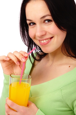 Young attractive woman drinks orange juice using drinking straw, isolated over whiteの写真素材