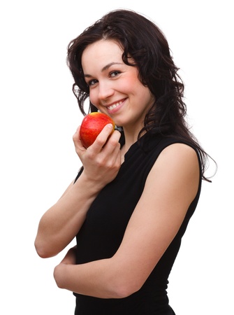 Portrait of a young attractive woman with red apple, isolated over whiteの写真素材