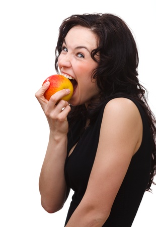 Young attractive woman is biting red apple, isolated over whiteの写真素材