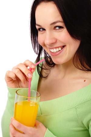 Young attractive woman drinks orange juice using drinking straw, isolated over whiteの写真素材