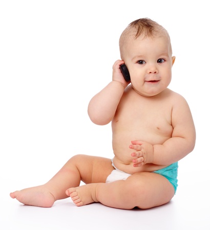 Cute little baby is talking on cell phone, isolated over whiteの写真素材