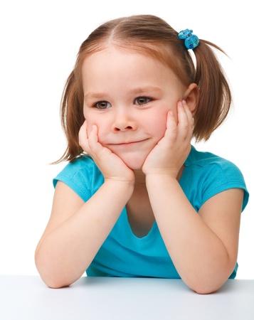 Portrait of a cute little girl holding her face with hands, isolated over whiteの写真素材