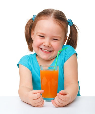 Happy little girl with orange juice, isolated over whiteの写真素材