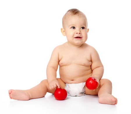 Portrait of a cute little child with two red apples, isolated over whiteの写真素材