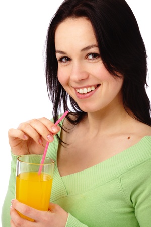 Young attractive woman drinks orange juice using drinking straw, isolated over whiteの写真素材