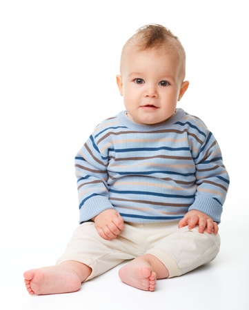 Happy child is sitting on floor, isolated over whiteの写真素材