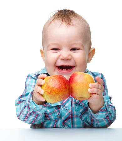 Portrait of a cute little child with two red apples, isolated over whiteの写真素材