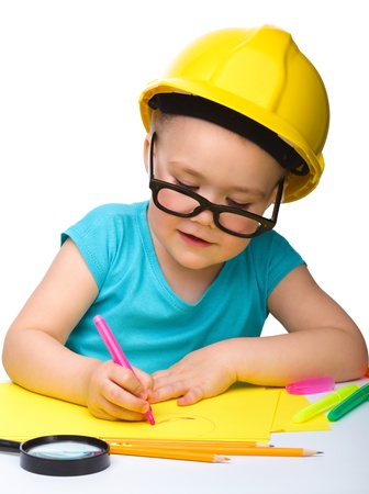 Cute little girl draw with marker wearing hard hat, isolated over whiteの写真素材