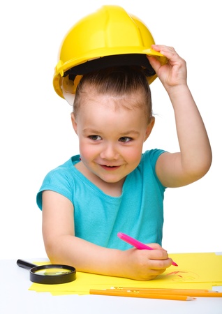Cute little girl draw with marker wearing hard hat, isolated over whiteの写真素材