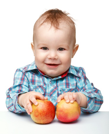 Portrait of a cute little child with two red apples, isolated over whiteの写真素材