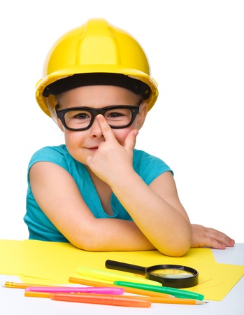 Cute little girl is playing while wearing hard hat, isolated over whiteの写真素材