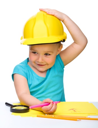 Cute little girl draw with marker wearing hard hat, isolated over whiteの写真素材