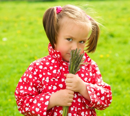 Cute little girl holding bunch of herbsの写真素材