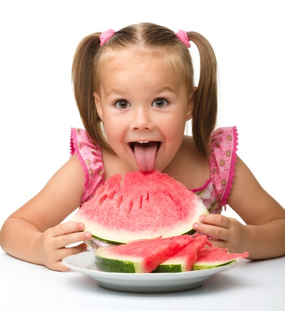 Cute little girl is gungy to eat watermelon, isolated over whiteの写真素材
