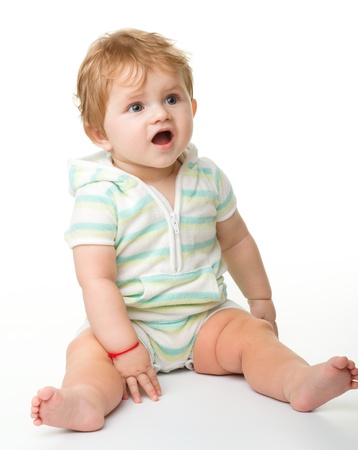 Happy child is sitting on floor, isolated over whiteの写真素材