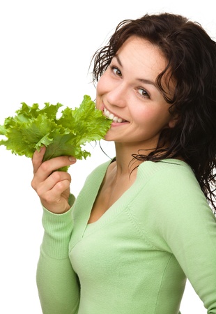 Beautiful young girl with green lettuce leaf, isolated over whiteの写真素材
