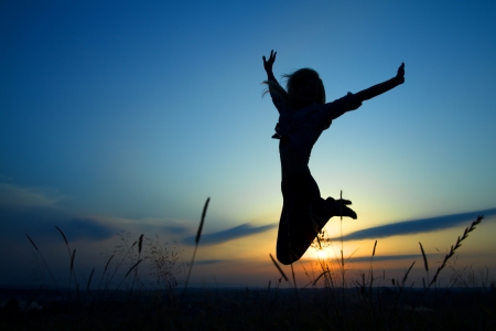 Silhouette of a beautiful girl jumping over sunset Silhouette of a beautiful girl jumping over sunset