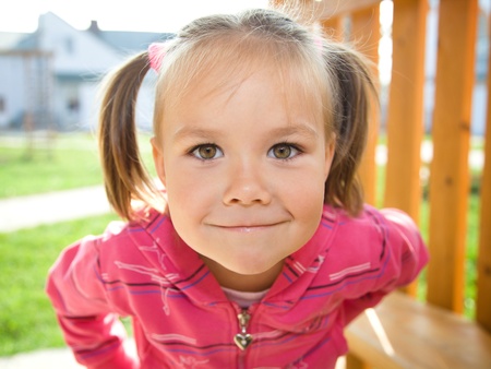 Portrait of a cute little girl playing on playgroundの写真素材
