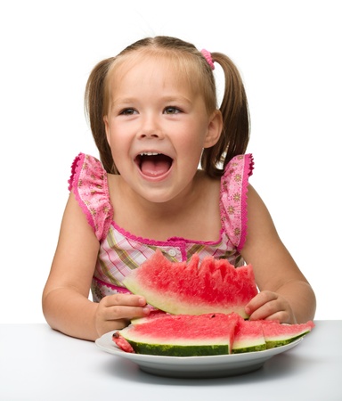 Cute little girl is gungy to eat watermelon, isolated over whiteの写真素材