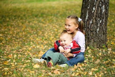 Cute children are playing in autumn parkの写真素材