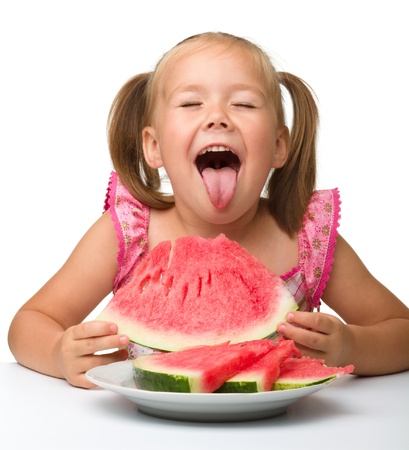 Cute little girl is gungy to eat watermelon, isolated over whiteの写真素材