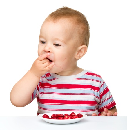 Cute little boy with strawberries, isolated over whiteの写真素材