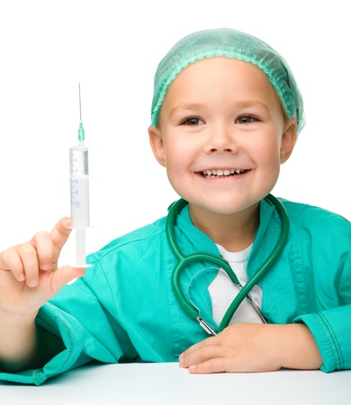 Cute little girl is playing doctor with syringe, isolated over whiteの写真素材