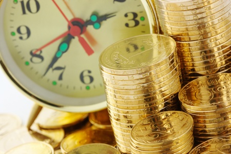Old-fashioned clock dial on golden coins background, time is money conceptの写真素材