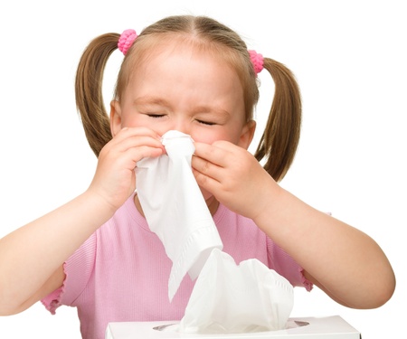 Little girl blows her nose, isolated over whiteの写真素材