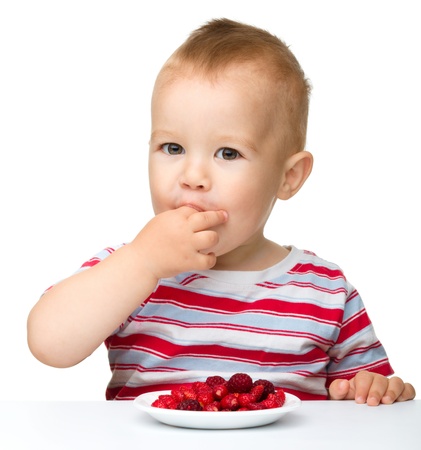 Happy little boy with strawberries, isolated over whiteの写真素材