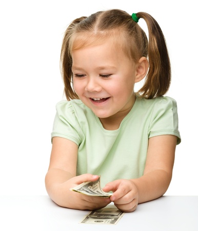 Cute cheerful little girl with paper money - dollars, isolated over whiteの写真素材