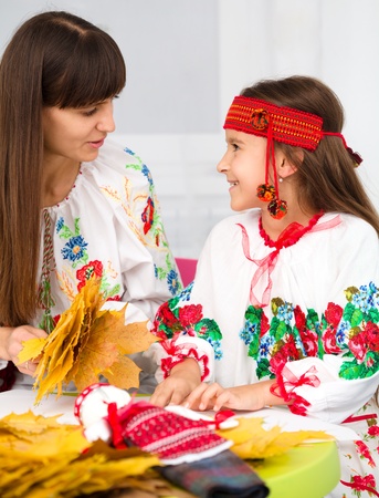 Mother and child in Ukrainian national cloth doing craftsの写真素材