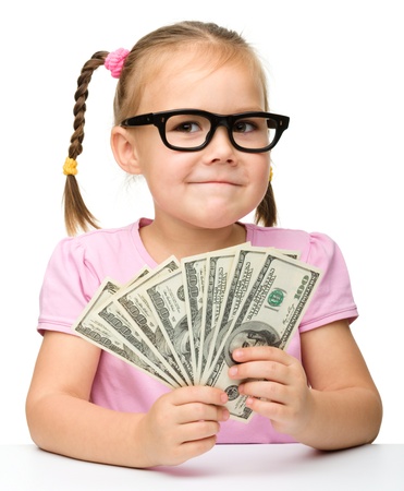 Cute cheerful little girl with paper money - dollars, isolated over whiteの写真素材